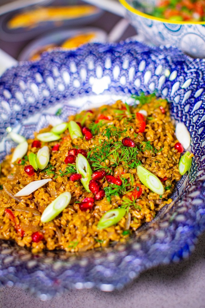freekeh pilaf with pomegranate in blue bowl